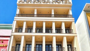 Un hotel de varios pisos con balcones, una recepción decorada con flores y un cielo despejado.