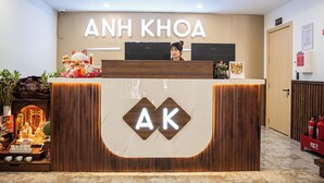 Una recepción con un cartel que dice "ANH KHOA" y un logotipo "AK".