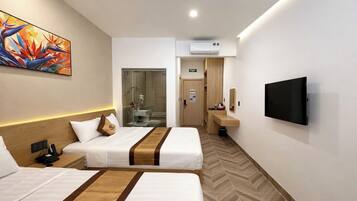 Une chambre d’hôtel avec deux lits, une télévision, une douche et une petite salle de bain.