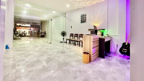 A modern interior with a glass partition, a wooden desk, a fan, and a guitar. - Jasmine Residence (Patong)