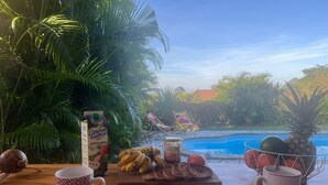 Ein Holztisch mit einem tropischen Getränk, Brotscheiben und einer Ananas.