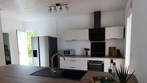 Eine moderne Küche mit Holzarbeitsplatte, Edelstahlspüle und eingebautem Backofen.