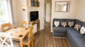 Ein modernes Wohnzimmer mit einem grauen Sofa, einem Holzesstisch und Stühlen.