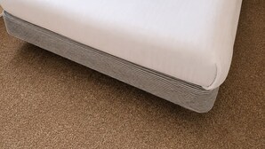 Ein Hotelzimmer mit einem Bett, einem Holzkopfbrett und einem Nachttisch.