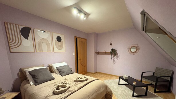 Un dormitorio con cama, una silla, un escritorio y una ventana.