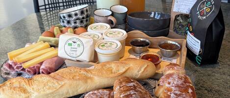 Una mesa con diferentes alimentos, como pan, queso y salsas.