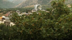 A view of a mountainous landscape with a modern building featuring a curved glass facade. - Studio chaleureux avec vue montagne au cœur de Font-Romeu (Font-Romeu-Odeillo-Via)
