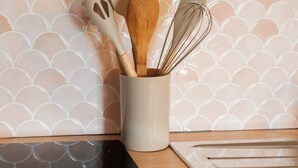A kitchen counter with a spatula, whisk, and wooden spoon in a white container. - Studio chaleureux avec vue montagne au cœur de Font-Romeu (Font-Romeu-Odeillo-Via)