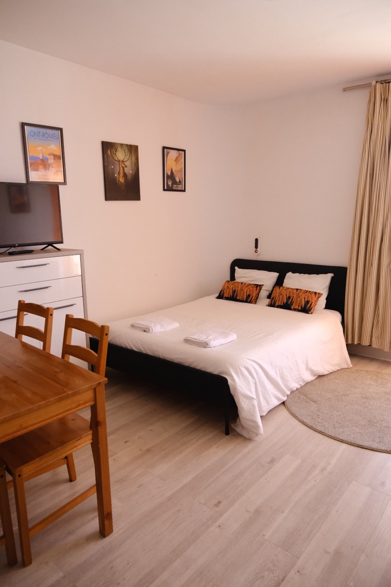 Un dormitorio con cama, mesitas de noche, un escritorio y sillas.