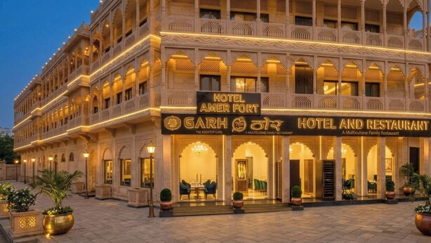 A multi-story hotel with a traditional architectural style, featuring balconies and arched windows. - Hotel Amer Fort (Amer)
