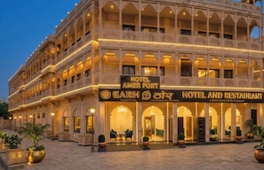 A multi-story hotel with a traditional architectural style, featuring balconies and arched windows.