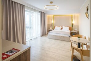 A hotel room with a bed, bedside tables, a desk, a chair, and a round table. - Hotel Anina (Techirghiol)