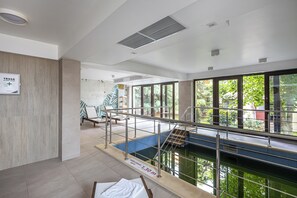 An indoor swimming pool with a clear view of the outside, a sign indicating a 7.30m depth, and a wooden wall on the left. - Hotel Anina (Techirghiol)