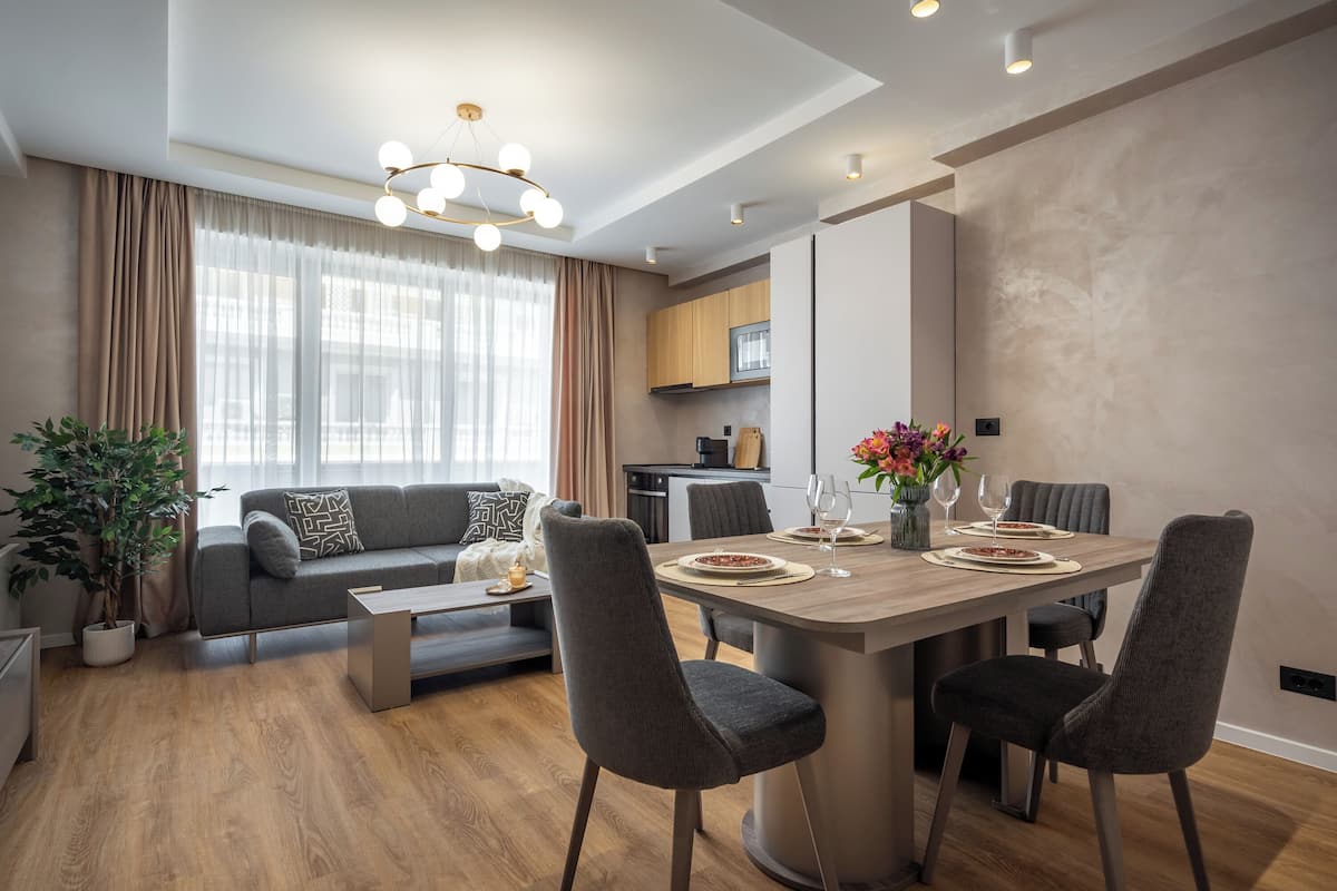 Una sala de estar moderna con zona de comedor, que incluye un sofá, una mesa de centro y una mesa de comedor con sillas.