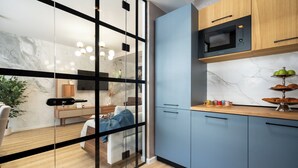 A modern kitchen with a built-in microwave, wooden cabinets, and a marble backsplash. - Manu Art Living (Bucharest)