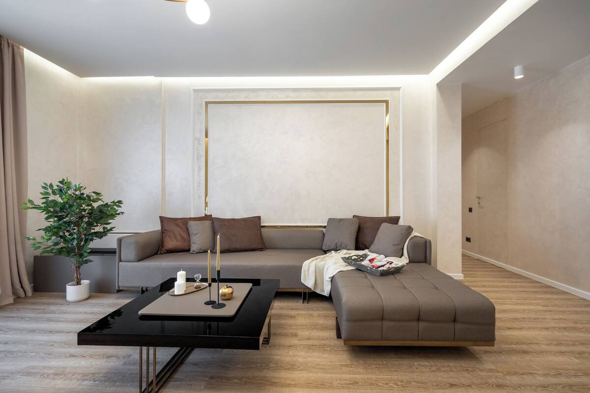 Una sala moderna con un sofá modular, una mesa de centro y una planta en maceta.