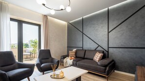A modern living room with a sectional sofa, two armchairs, a coffee table, and a large window with curtains. - Manu Art Living (Bucharest)
