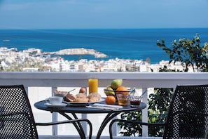 A balcony with a table set for breakfast, overlooking a coastal cityscape. - Bianca Doma Adults Only by Estia (Koutouloufari)