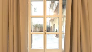 A double door with a view of a courtyard and a building in the background. - Loft Portici by Piazza Vittorio (Torino)