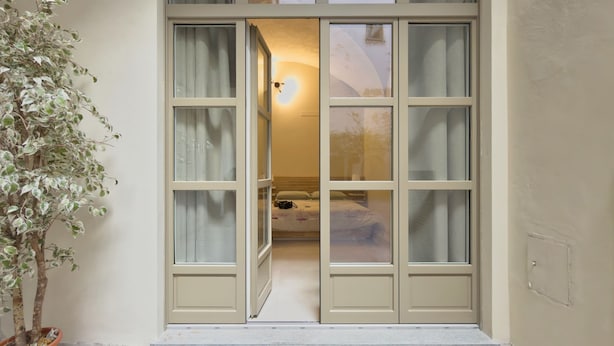 A room with a bed, a nightstand, and a potted plant. - Loft Portici by Piazza Vittorio (Torino)