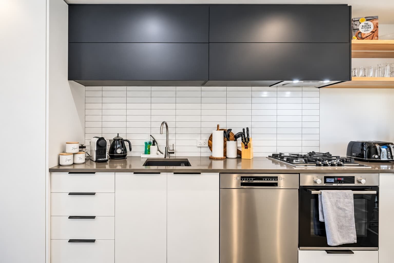 Una cocina moderna con lavavajillas, horno y cafetera.
