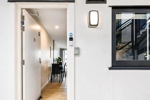 A hallway with a dining area, a door labeled 'E5', and a window with a view of a building outside.