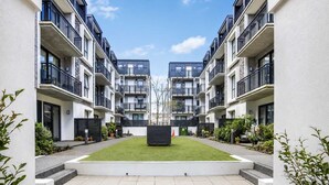 A modern apartment complex with a central courtyard, balconies, and a clear sky. - Newtown Tranquility | 2BR Wellington | Kitchen (Wellington)