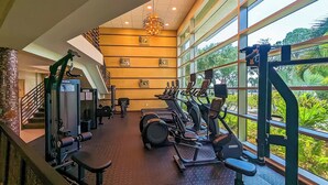 Une salle de sport équipée de machines de cardio, de matériel de musculation et d’un escalier.