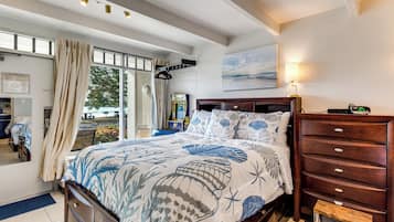 Un dormitorio con cama, cómoda, mesita de noche, lámpara y un cuadro en la pared.