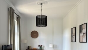 Un salon moderne avec un téléviseur à écran plat, une table basse ronde, un canapé gris, un tapis blanc et un meuble en bois.