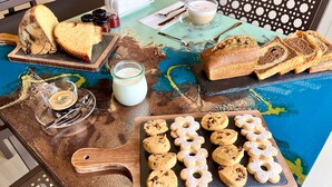 A table with various food items including bread, cookies, and a glass of milk. - Uliveto Magico (Cannara)