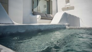A white building with a window and a small balcony with striped cushions. - Villa Pisti, Apleton Villas Paros (Paros)