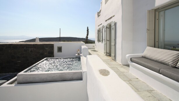 A rooftop terrace with a pool, a seating area with cushions, and a view of the sea and hills. - Villa Pisti, Apleton Villas Paros (Paros)