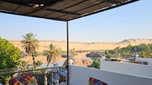 A balcony with a view of a desert landscape, including palm trees and distant hills. - Timo Pyramids View : Deluxe Queen Room (Giza Governorate)