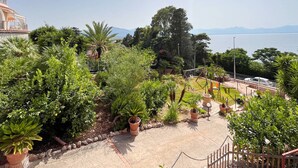 A landscaped garden with various plants and a paved walkway. - Solemar Sicilia - Villa Elis (Bagheria)
