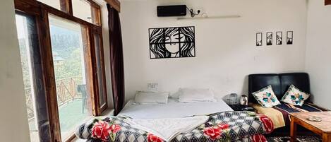 A bedroom with a bed, a desk, a chair, a ceiling fan, and a window.