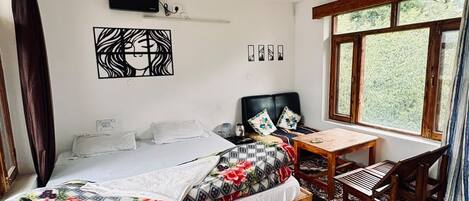 A bedroom with a bed, a desk, a chair, a ceiling fan, and a window.