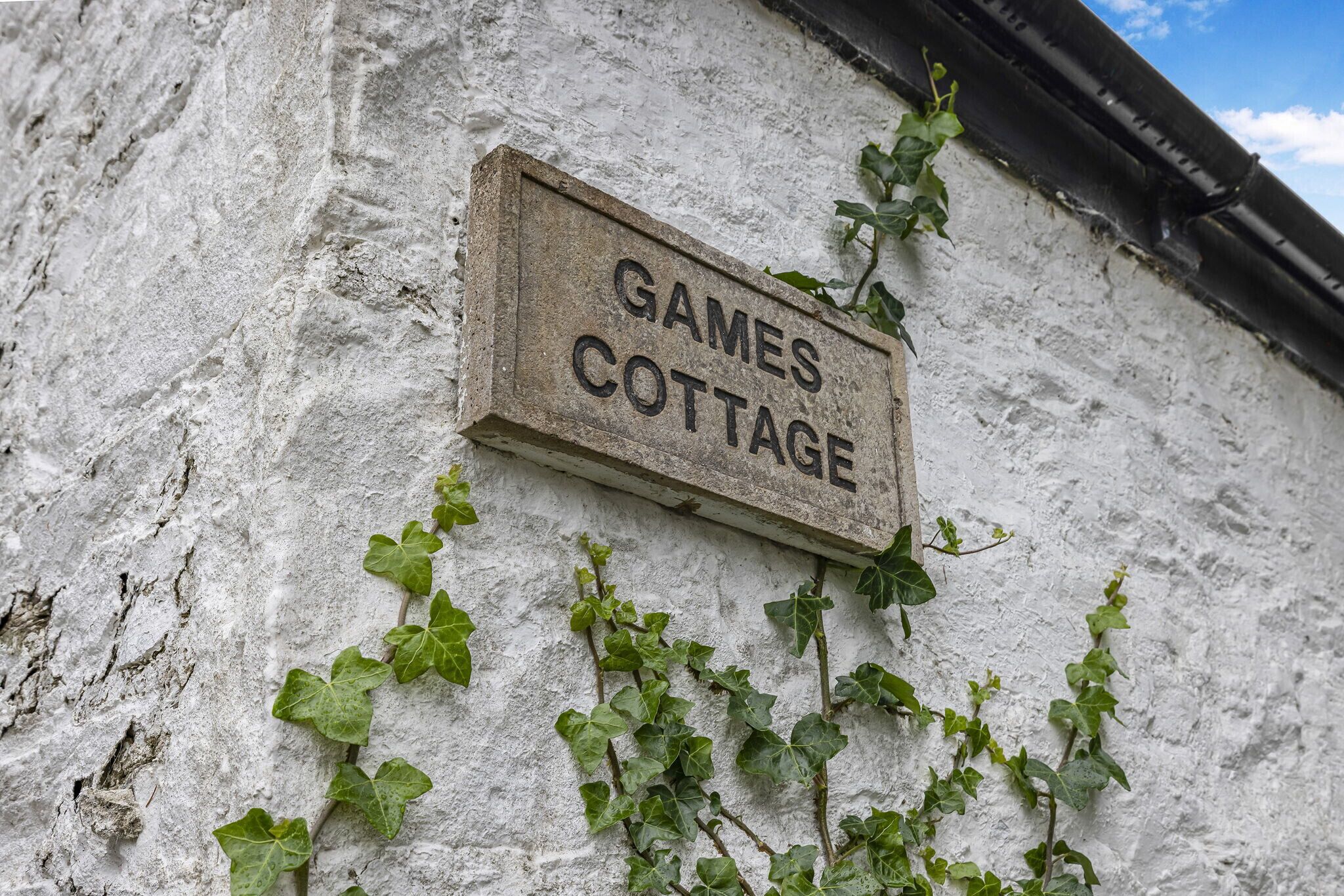 A sign on a building wall reading "GAMES COTTAGE."