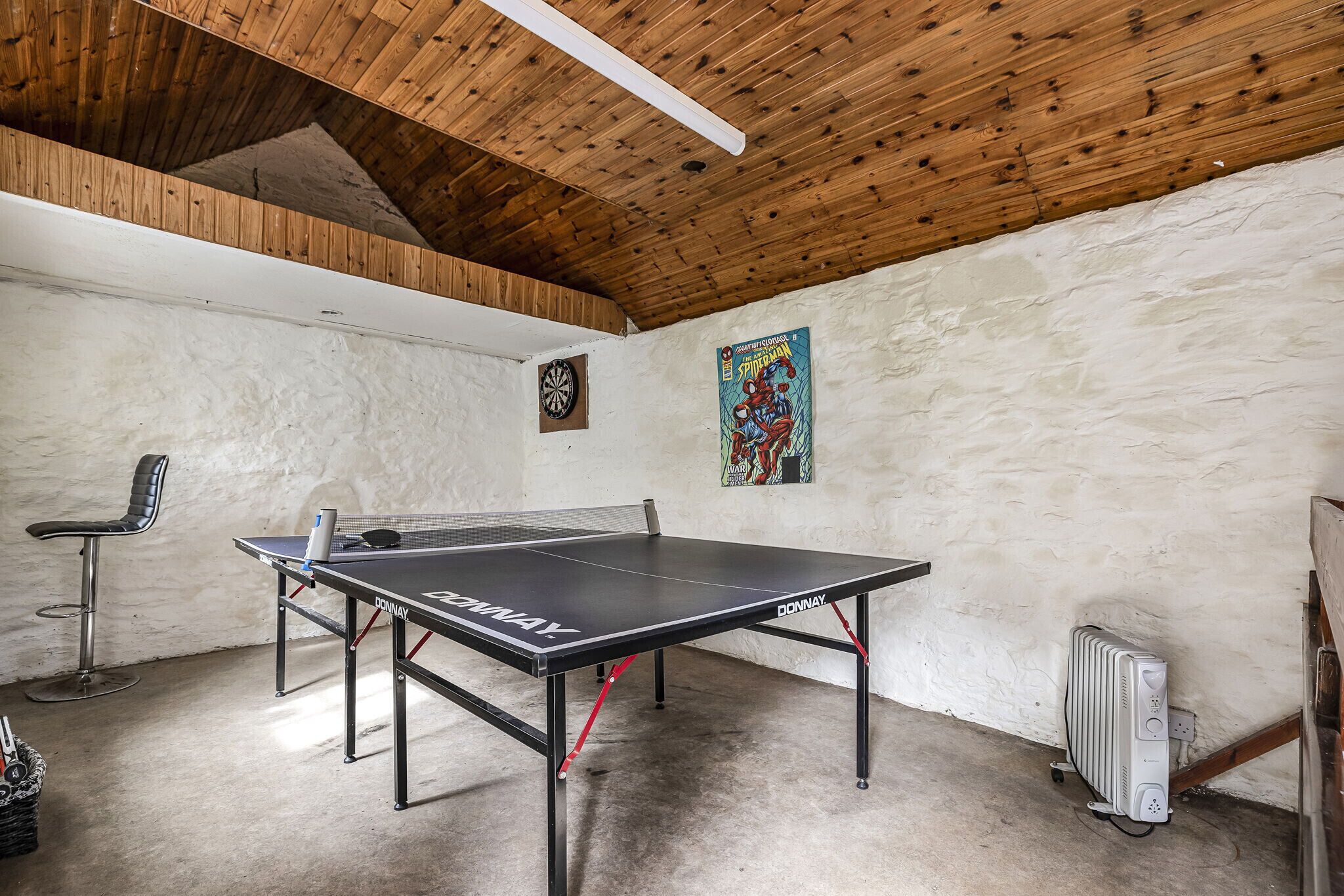 Ein Tischtennis-Tisch mit Wandpfeil und einem Poster.