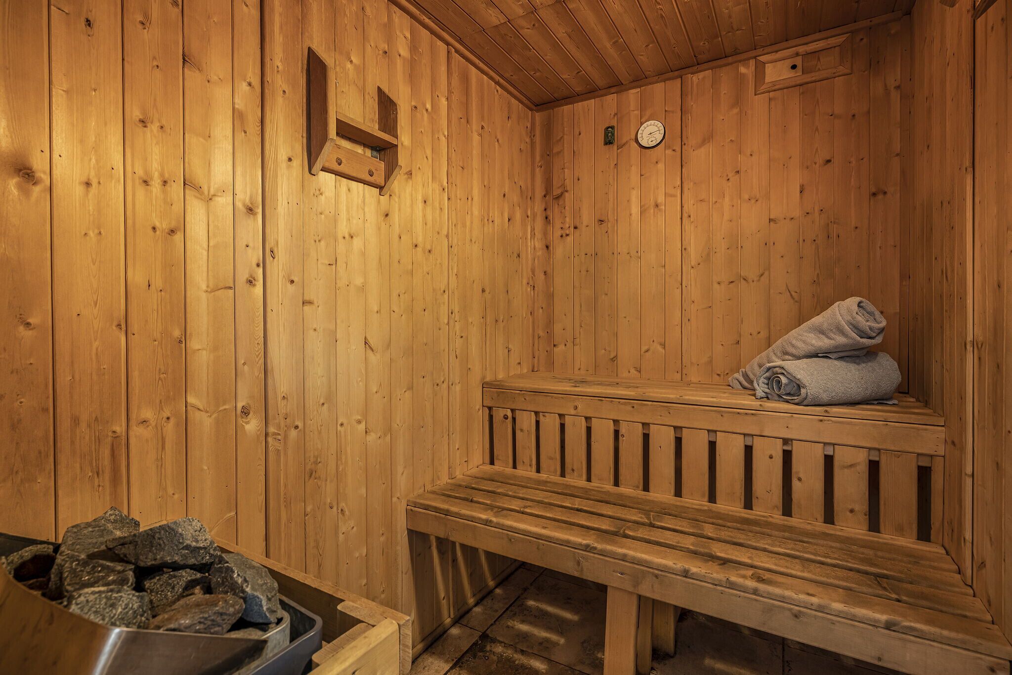 Eine Holzsauna mit Bänken, darunter eine Bank mit einem Handtuch.