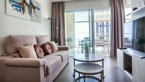 A modern living room with a sofa, a round table, and a TV. - Intempo by Holuxe - 034 - 3rd floor (Benidorm)