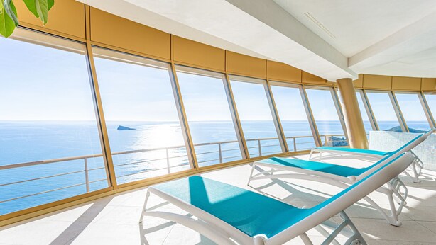 A sunlit deck with lounge chairs facing a large window overlooking the sea. - Intempo by Holuxe - 034 - 3rd floor (Benidorm)