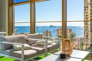A modern living room with a large window, a sofa, a table, and a decorative vase. - Intempo by Holuxe - 023 - 2nd floor (Benidorm)