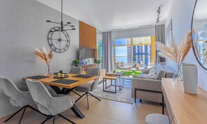 A modern living room with a dining area, large windows, and a view of the cityscape. - Intempo by Holuxe - 023 - 2nd floor (Benidorm)