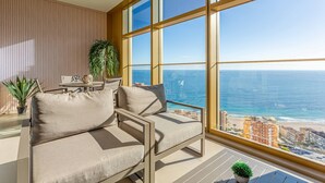 Ein Balkon mit einer Couch, einem kleinen Tisch und einem Blumentopf.