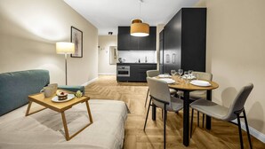 Eine moderne Wohnung mit Wohnbereich, Esstisch und Küche.