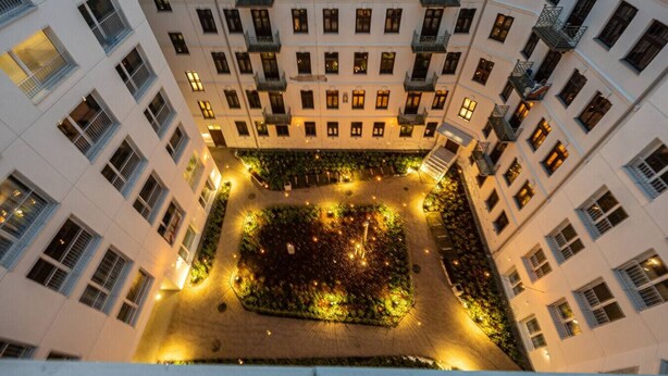Ein mehrstöckiges Hotel mit Innenhof, der einen Garten und Sitzbereiche bietet.