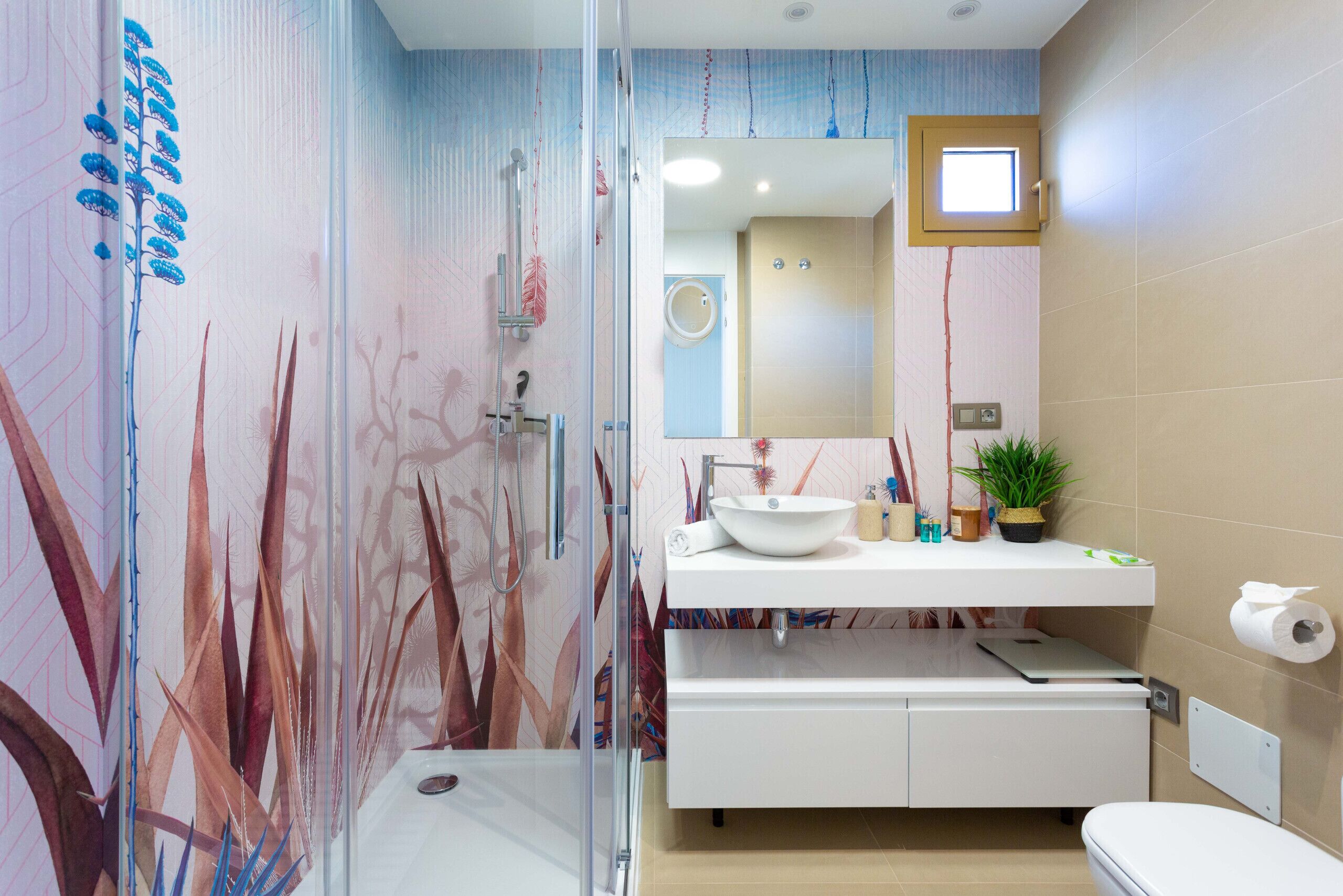 A modern bathroom with a glass shower enclosure, a white sink, and a toilet.