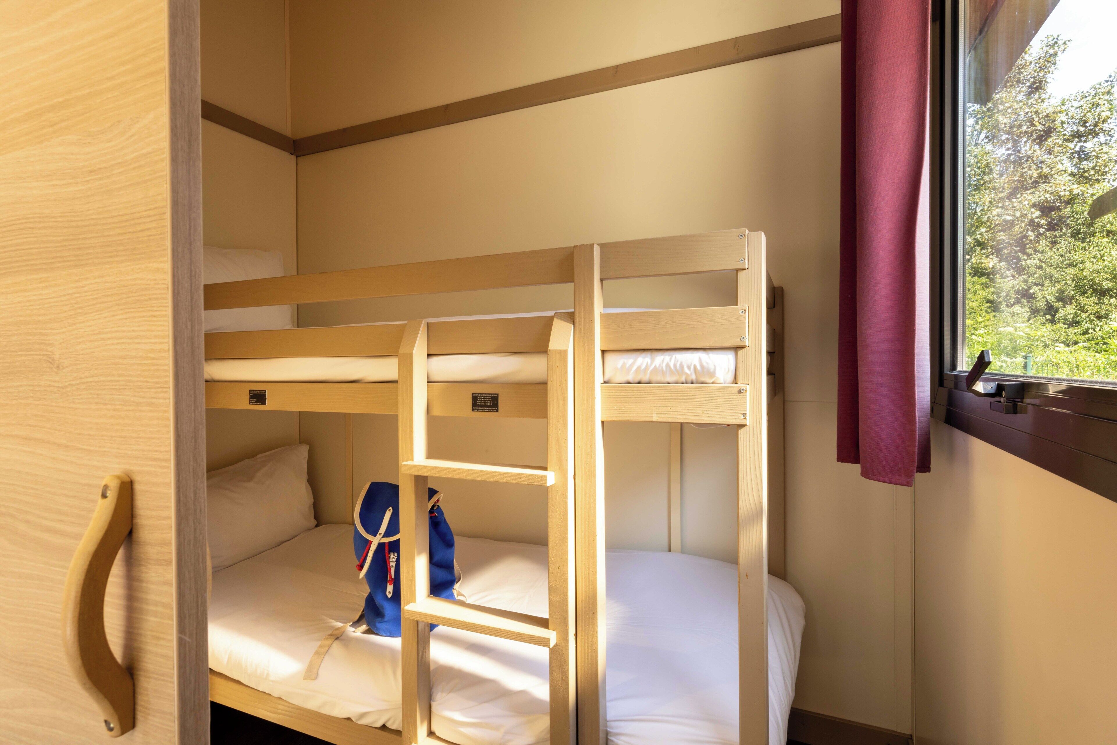 A bunk bed room with a window and a door.