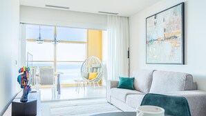 Una sala moderna con un sofá, una silla, una mesa y un ventanal con vistas.
